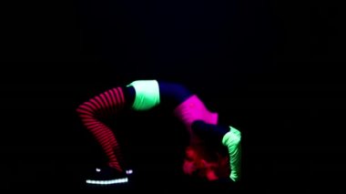 Kadın floresan giyim Uv ultraviyole ışık altında jimnastik egzersizleri yapıyor