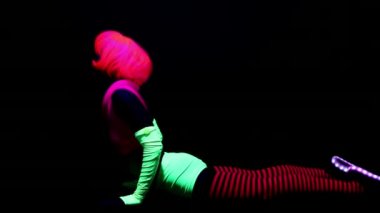 Kadın floresan giyim Uv ultraviyole ışık altında jimnastik egzersizleri yapıyor