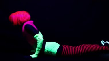 Kadın floresan giyim Uv ultraviyole ışık altında jimnastik egzersizleri yapıyor