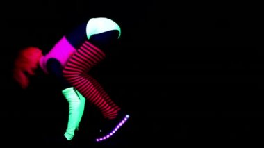 Kadın eğitim ve Uv ultraviyole ışık altında egzersizleri yapıyor floresan giyim