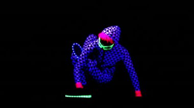 Kadın eğitim ve Uv ultraviyole ışık altında egzersizleri yapıyor floresan giyim