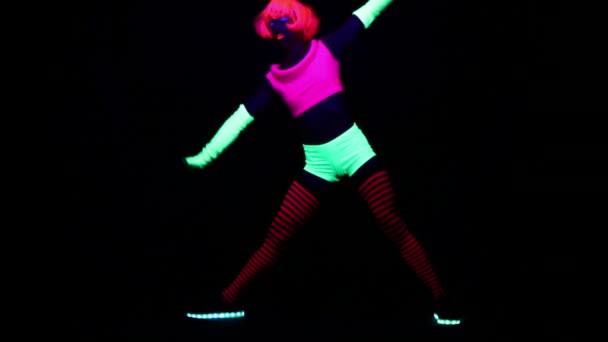ブラック ライトの下で体操を行う蛍光服の女性 — ストック動画