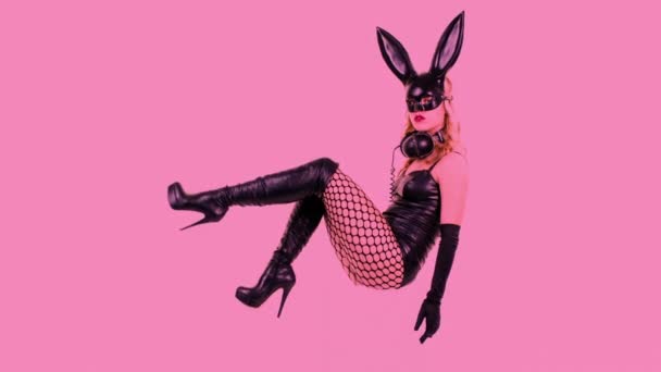 若い女性が耳のウサギのマスクと黒のラテックス体ポーズ — ストック動画