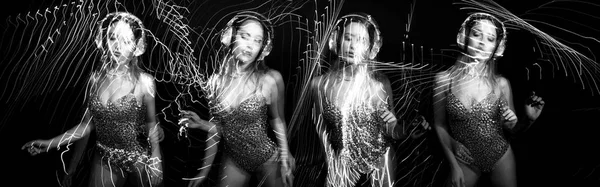 美丽的性感女舞者与耳机在迪斯科场景与叠加激光灯 黑色和白色 — 图库照片