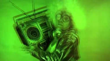 Muhteşem büyükanne DJ, ghettoblaster 'lı yaşlı bayan disko ortamında parti yapıyor, üstü kapalı video çarpıtma ve arıza efekti ile..