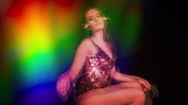 美しい輝くカーニバルの衣装とレトロなヘッドフォンを着てクラブに座っているセクシーな女性 — ストック動画