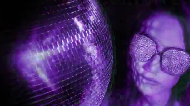 美丽的模型摆姿势旁边的迪斯科球与闪闪发光的眼镜和闪闪发光的效果 — 图库视频影像
