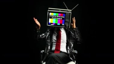 Başında televizyon ile sandalyede oturan adam 