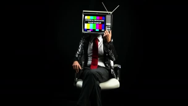 頭にテレビを持つ椅子に座っている男 — ストック動画