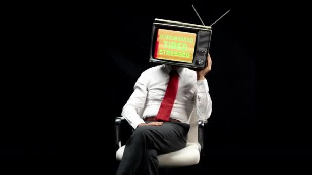 黒い背景に頭の上にテレビで座っている男 — ストック動画
