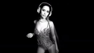 Siyah arka planda hareket eden vücut ve kulaklık güzel kadın