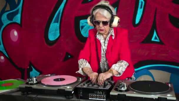 Старшая Женщина Наушниках Против Граффити — стоковое видео