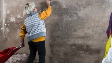 Duvara grafiti çizim sepeti ile Kıdemli kadın