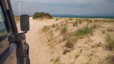 Adam yol manzaralı bir araba kullanıyor.