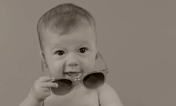 Αξιολάτρευτο Μικρό Κοριτσάκι Κρατώντας Γυαλιά Ηλίου Απλό Φόντο — Φωτογραφία Αρχείου