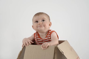 Çizgili elbiseli, karton kutuda oturan güzel kız. 