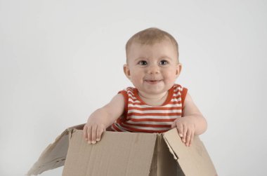 Çizgili elbiseli, karton kutuda oturan güzel kız. 