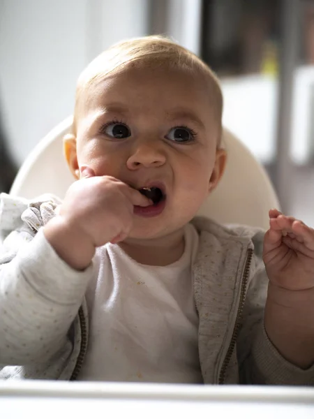 Adorable Baby Girl Ekspresyjnym Jedzenie Twarzy Wysokim Krześle — Zdjęcie stockowe