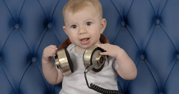 Divertida Niña Con Grandes Auriculares Sentados Sofá Cuero Azul — Foto de Stock