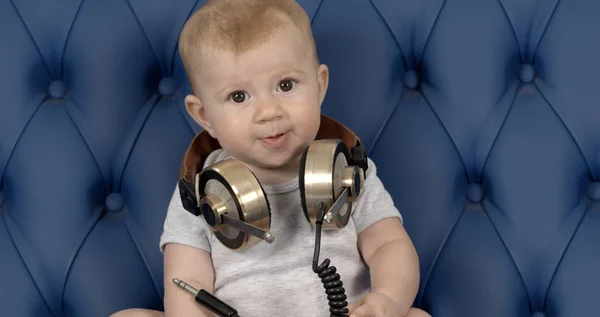 Divertida Niña Con Grandes Auriculares Sentados Sofá Cuero Azul — Foto de Stock