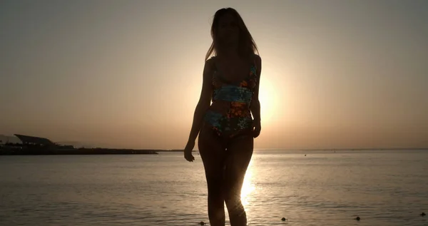 Красива жінка танцює на пляжі на сході сонця — стокове фото