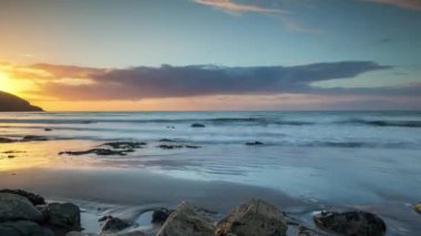 Gün batımında gelen ve giden gelgitin döngüsel videosu Galler 'de çekildi.