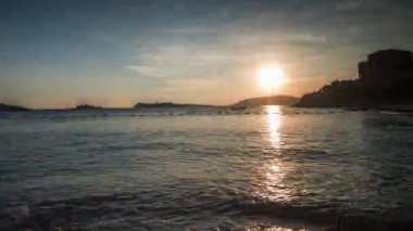 Akdeniz 'de dağın arkasında batan güneşin döngüsel videosu