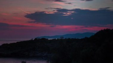 Gün batımında dağların üzerinden gökyüzünde hareket eden bulutların çevrilebilir videosu