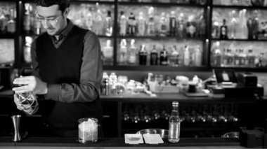 Barmen, siyah beyaz barda kokteylde kokteyl sallıyor.
