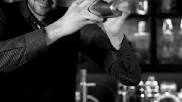 Бармен тремтить коктейль в шейкері в барі, чорно-білий — стокове відео