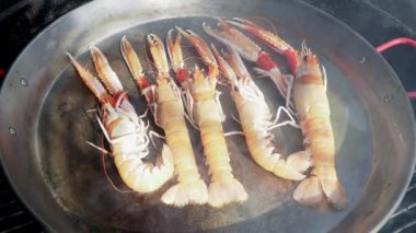 Paella tavasında taze deniz ürünleri pişirme videosunu kapat.