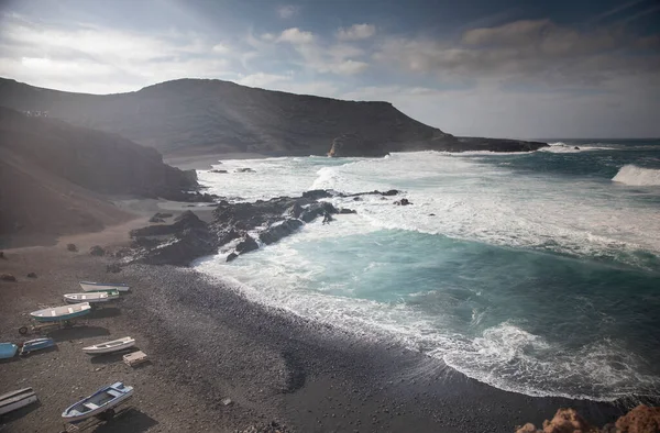 Łodzie rybackie na czarnym piasku, El Golfo, Lanzarote. — Zdjęcie stockowe