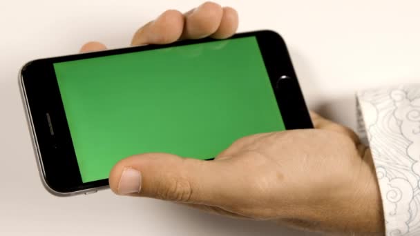 Henkilö, jolla on älypuhelin vihreällä näytöllä — kuvapankkivideo