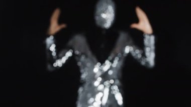 Gümüş ceketli Bay disko topu dans ediyor.