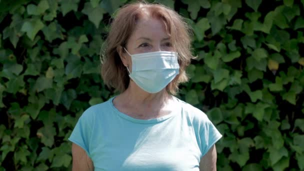Reife Frau trägt schützende Gesichtsmaske — Stockvideo