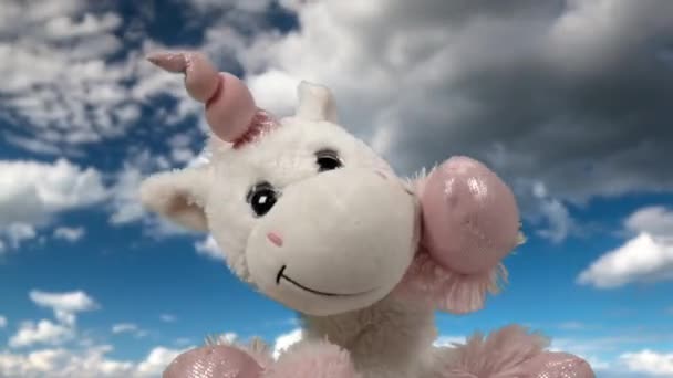 Juguete unicornio ondeando contra las nubes — Vídeos de Stock