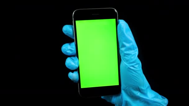 Videó a személy visel kesztyű tartó telefon zöld képernyővel — Stock videók
