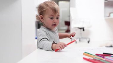 Keçeli kalemle çizim yapan genç bir kız.