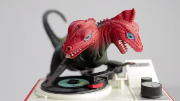 Іграшковий динозавр обертає диски на програвачі записів — стокове відео