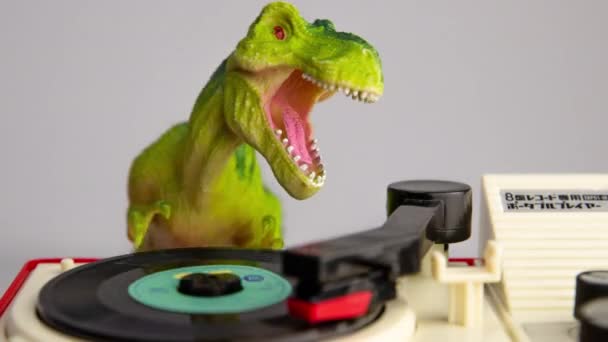 Toy dinosaur spinning discs on record player — Stock Video