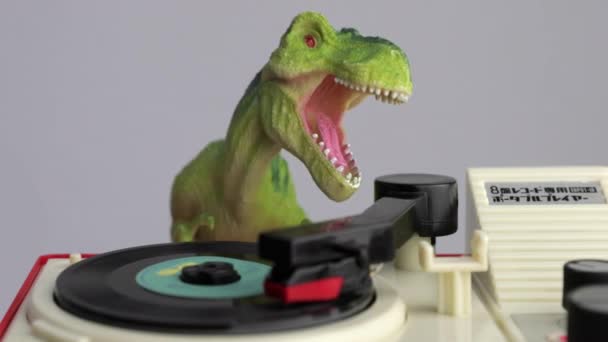 Toy dinosaur spinning discs on record player — Stock Video