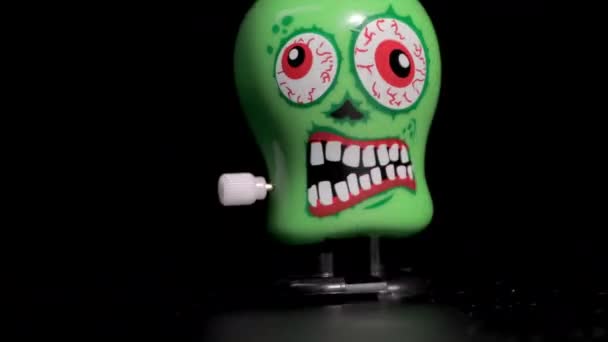 Green wind up skull toys moving on surface — Stock Video
