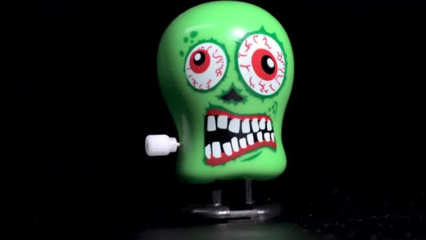 Green wind up skull toys moving on surface — Stock Video