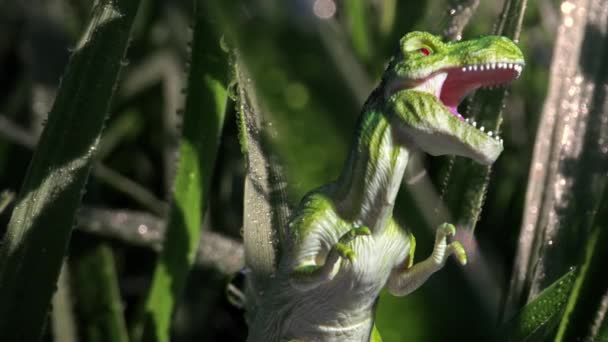 Toy dinosaur in green foliage — Stock Video