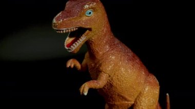 Plastik dinozorun siyah arkaplana karşı görüntüsü