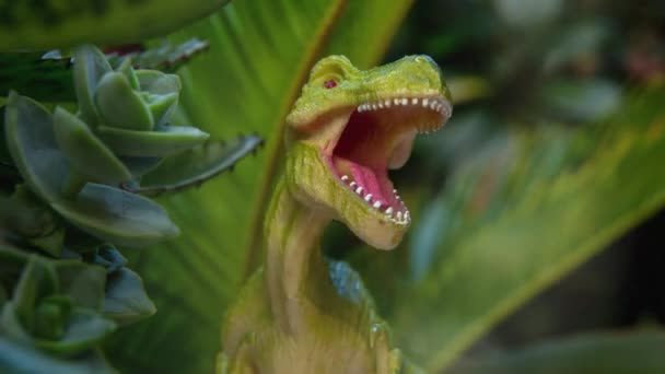 Іграшковий динозавр у зеленому листі — стокове відео