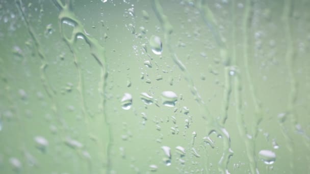 Nahaufnahme Von Wassertropfen Auf Fensterglas Mit Unscharfem Natürlichen Hintergrund — Stockvideo