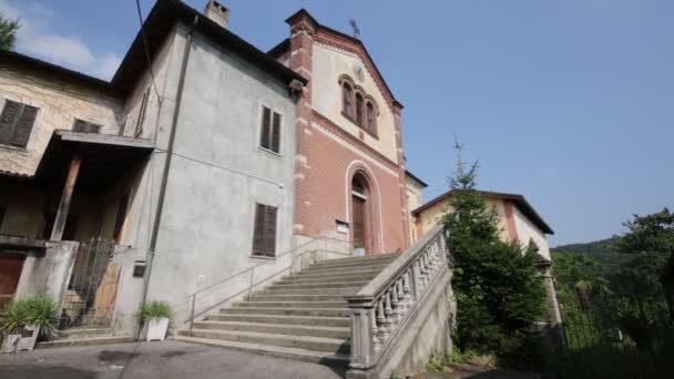 Stock video ancient catholic church with clock in osmate, Italy