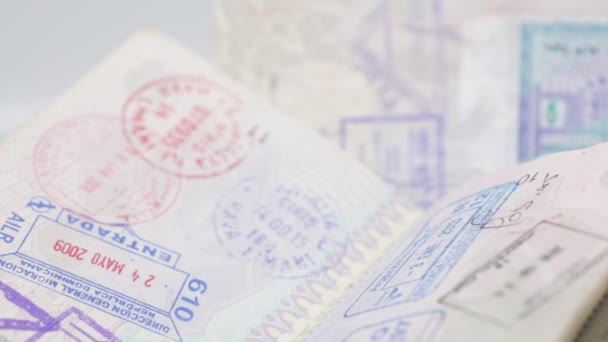 带有许多白色背景旅行邮票的特写镜头护照 — 图库视频影像