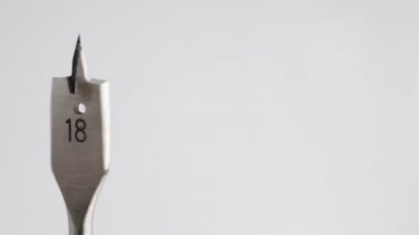 Manuel çalışma kavramı gibi beyaz arka planda bir matkap biti sayısının on sekiz dönüşü